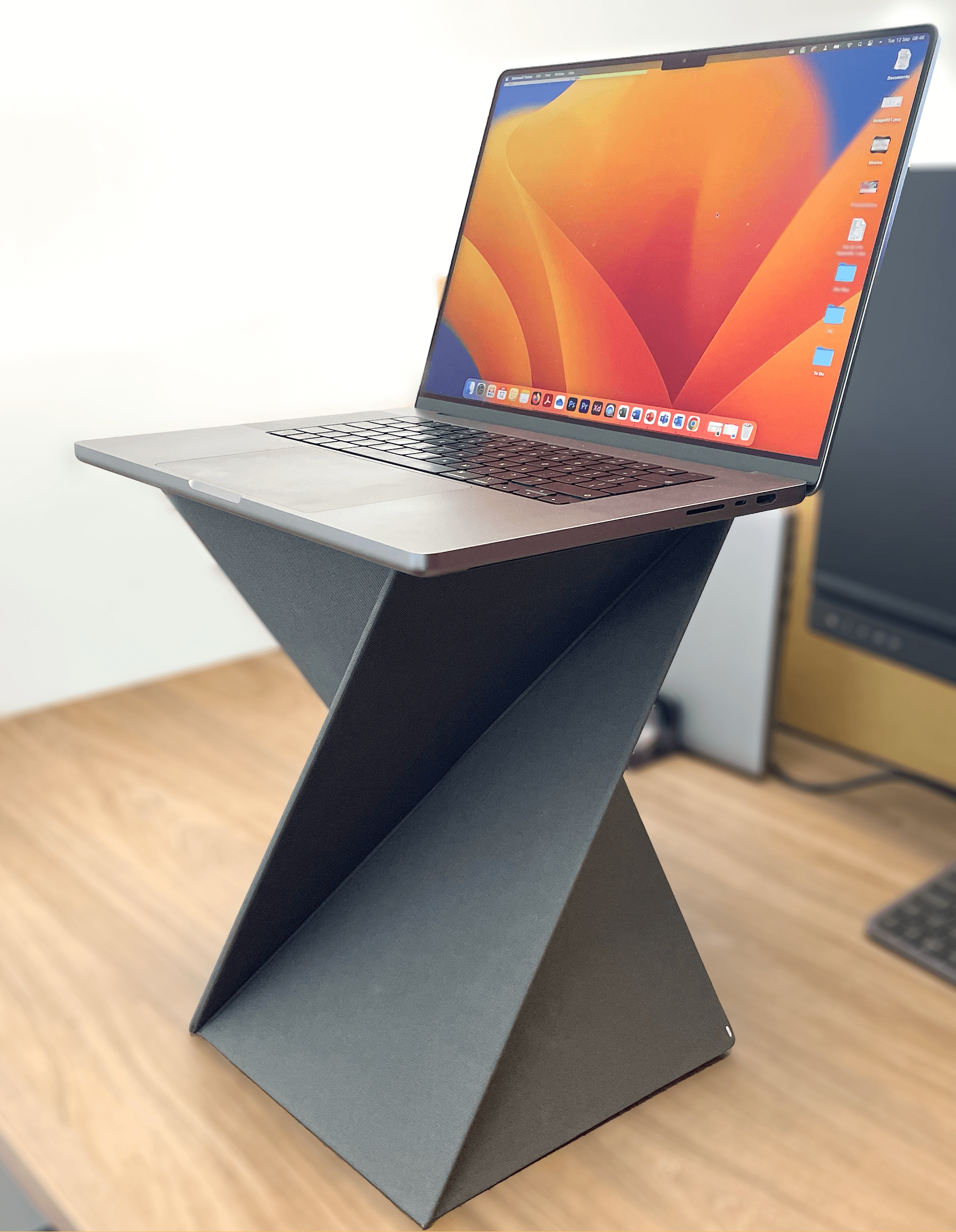 A 16" Macbook Pro sitting on top of the Levit8 Flat Folding Standing Desk in their Large size option